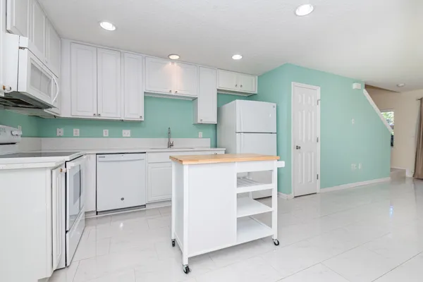 a kitchen with a refrigerator a sink and cabinets