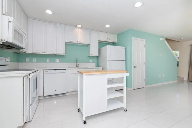 a kitchen with a refrigerator a sink and cabinets
