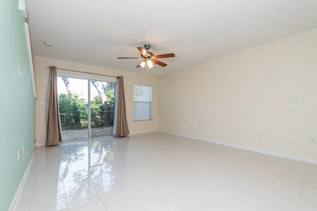 an empty room with windows and ceiling fan
