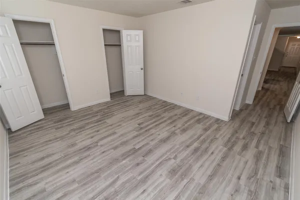an empty room with wooden floor and entrance