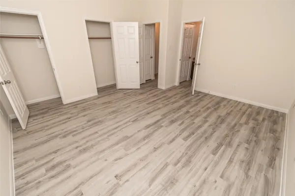 an empty room with wooden floor and entrance