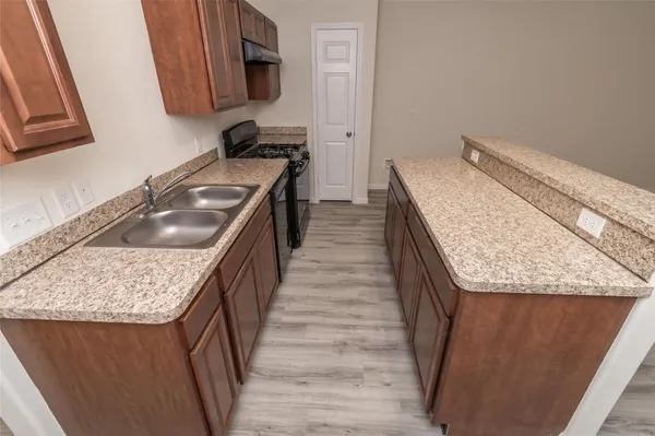a kitchen with a granite countertop sink and washing machine