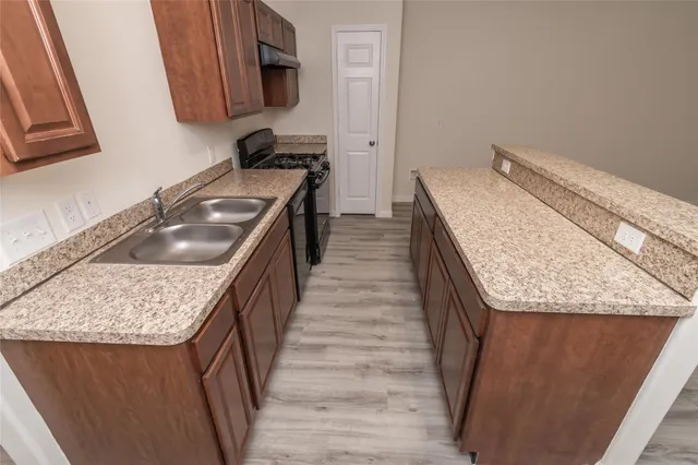 a kitchen with a granite countertop sink and washing machine
