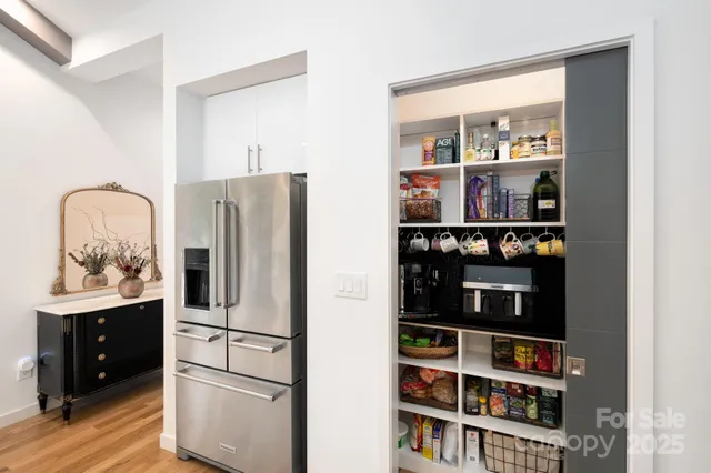 a kitchen with stainless steel appliances granite countertop a refrigerator and a wooden floor