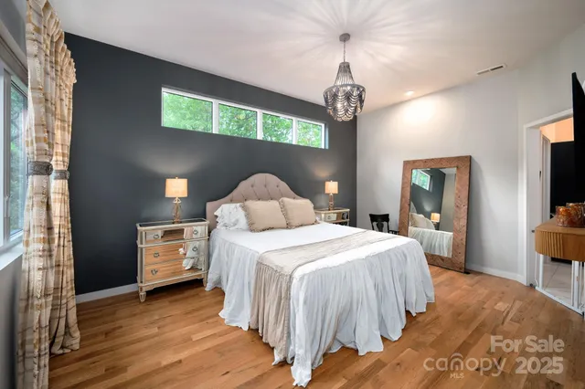 a bedroom with a bed and a chandelier