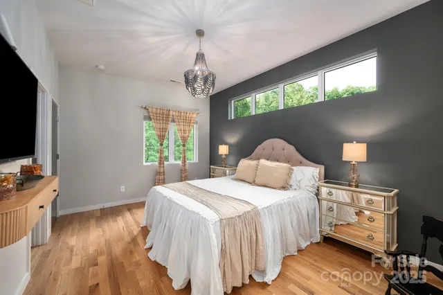 a bedroom with a bed and a flat tv screen on the dresser