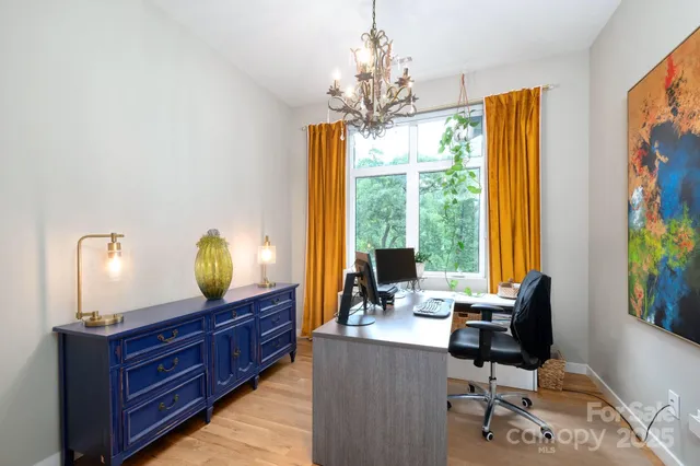 a view of a workspace with furniture and a window