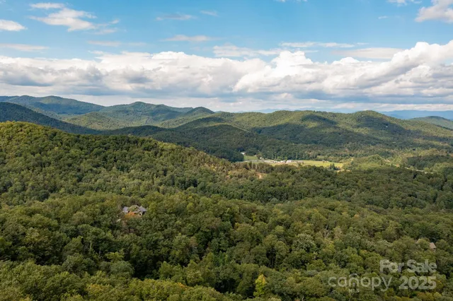 a view of a green field with mountains in the background