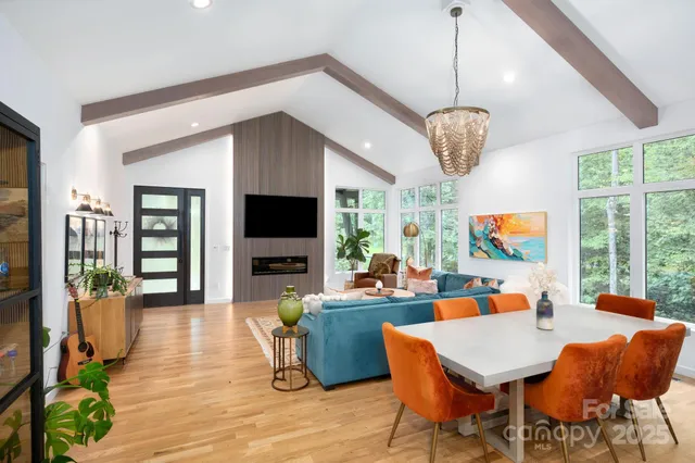 a living room with furniture a flat screen tv and a large window