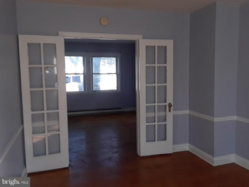 726 Braeside Road Baltimore, MD 21229 - Photo 3 of 15 an empty room with wooden floor and windows