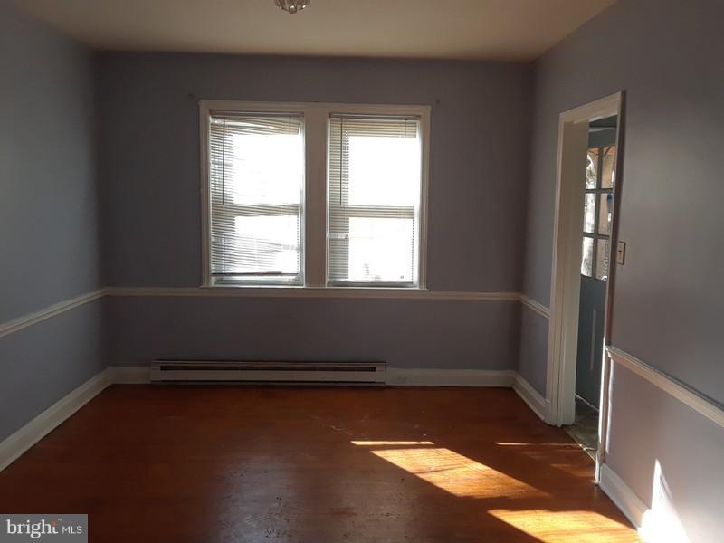 726 Braeside Road Baltimore, MD 21229 - Photo 4 of 15 an empty room with wooden floor and windows