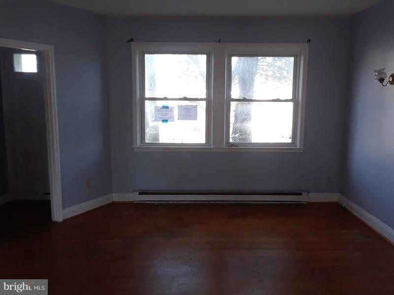 726 Braeside Road Baltimore, MD 21229 - Photo 6 of 15 an empty room with wooden floor and windows