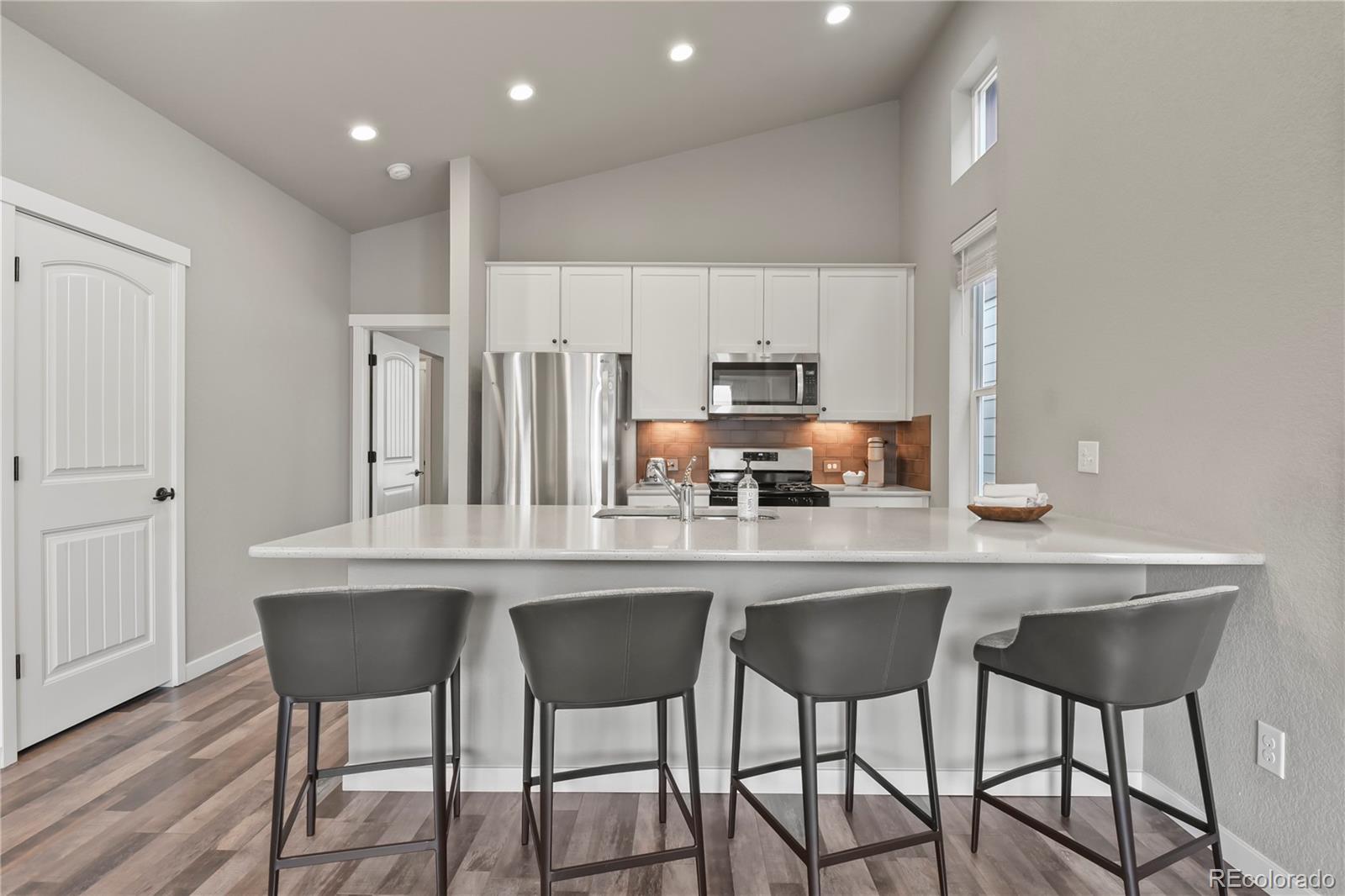 1344 Sunshine Valley Way Colorado Springs, CO 80921 - Photo 13 of 37 a kitchen with stainless steel appliances a dining table chairs refrigerator and cabinets