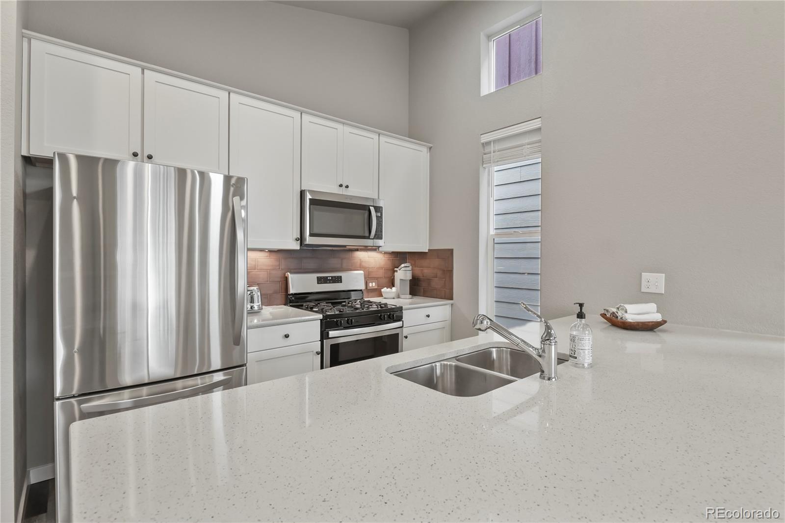 1344 Sunshine Valley Way Colorado Springs, CO 80921 - Photo 15 of 37 a kitchen with granite countertop a refrigerator stove and sink