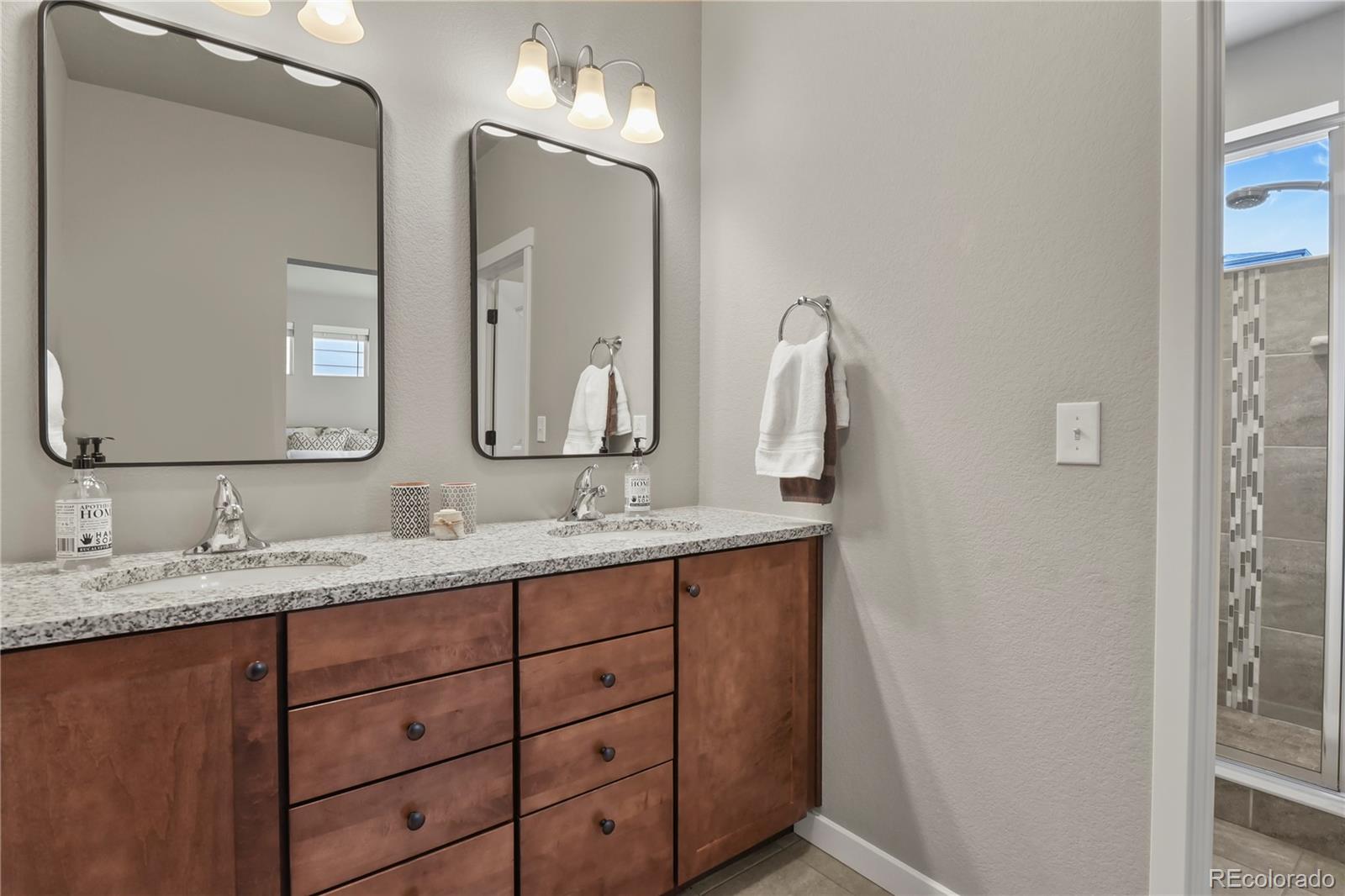 1344 Sunshine Valley Way Colorado Springs, CO 80921 - Photo 22 of 37 a bathroom with a double vanity sink and a mirror