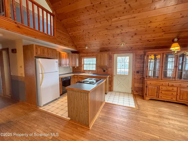 a kitchen with stainless steel appliances granite countertop a refrigerator a stove and a wooden floors