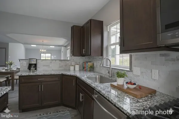 a kitchen with granite countertop stainless steel appliances sink stove and cabinets