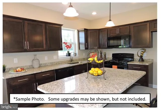 a kitchen with a sink a stove and a microwave