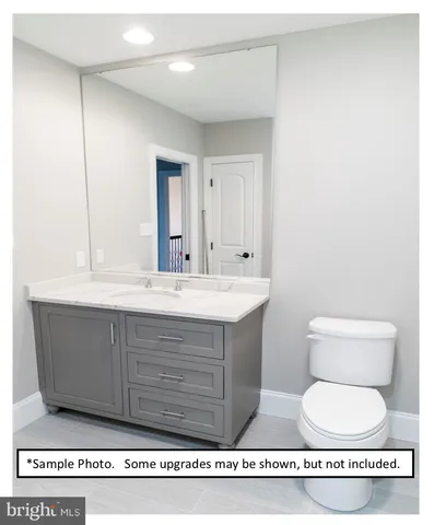 a bathroom with a toilet a sink and a mirror