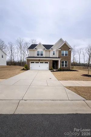 a front view of a building with large trees
