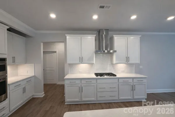 a kitchen with kitchen island granite countertop a sink cabinets and stainless steel appliances