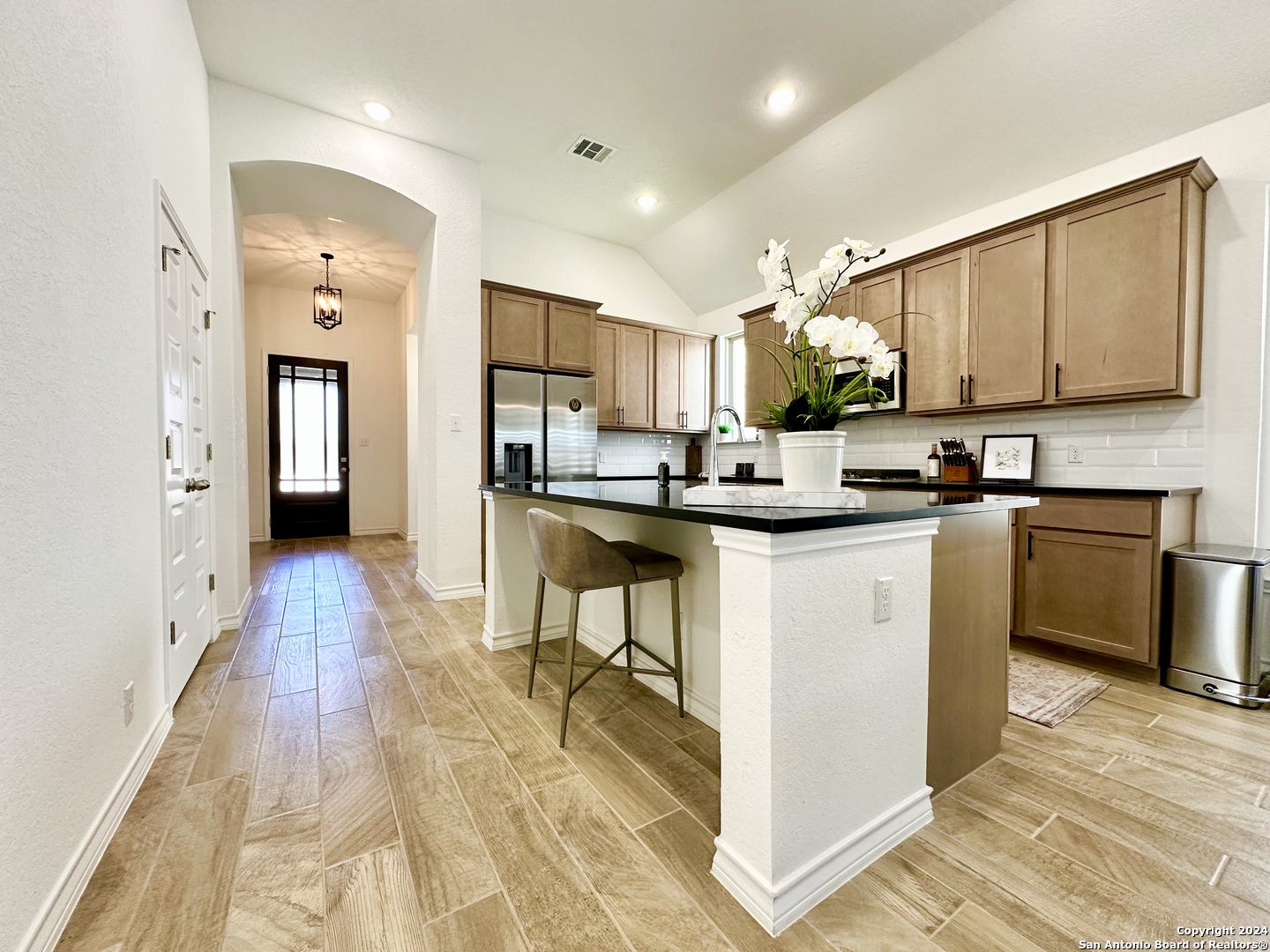 a kitchen with kitchen island granite countertop wooden floors and stainless steel appliances