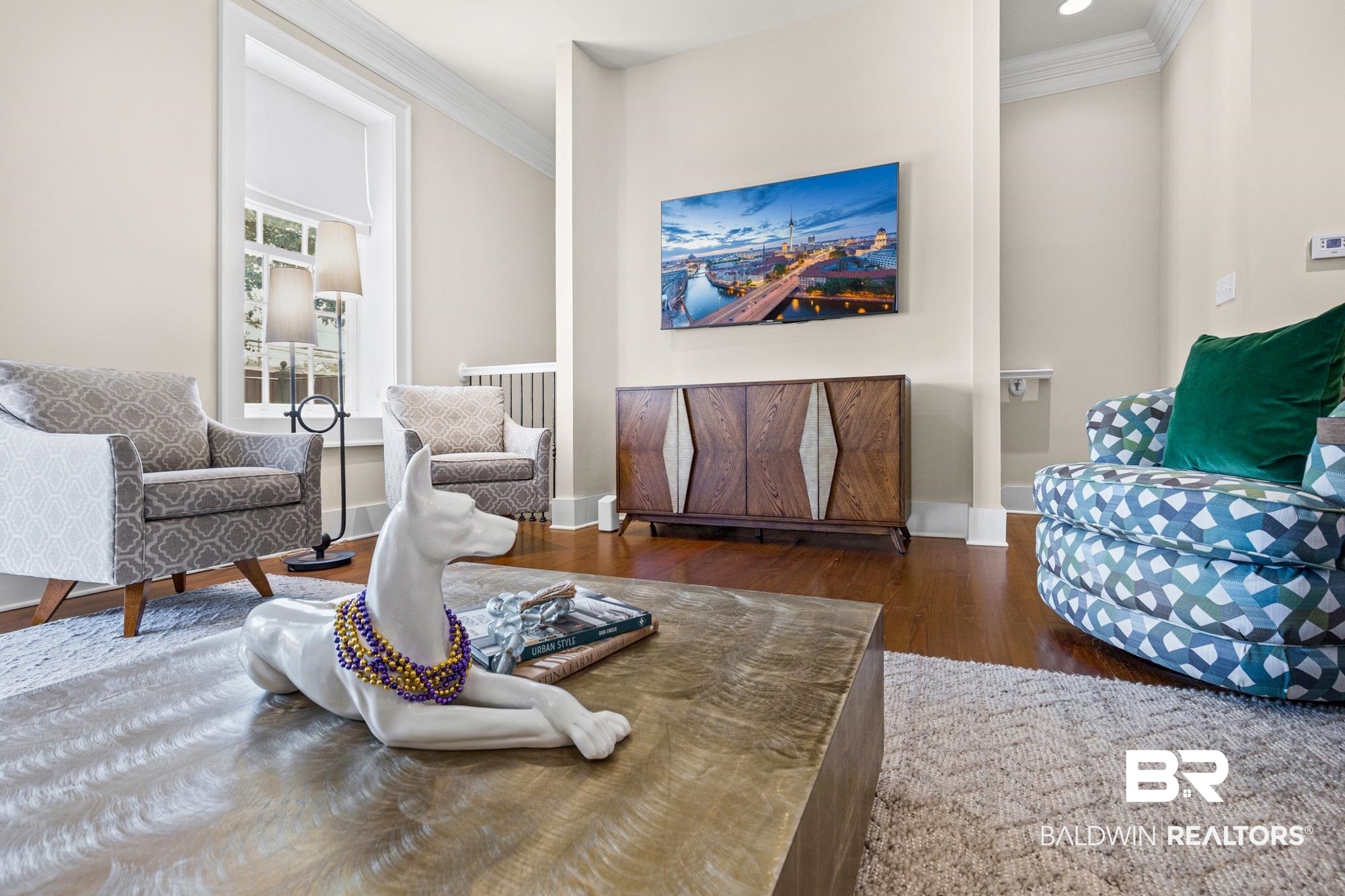 701 Dauphin Street, Unit A Mobile, AL 36602 - Photo 7 of 31 Hardwood flooring throughout this living area, featuring crown molding, neutral wall tones, and a wood-finish console table