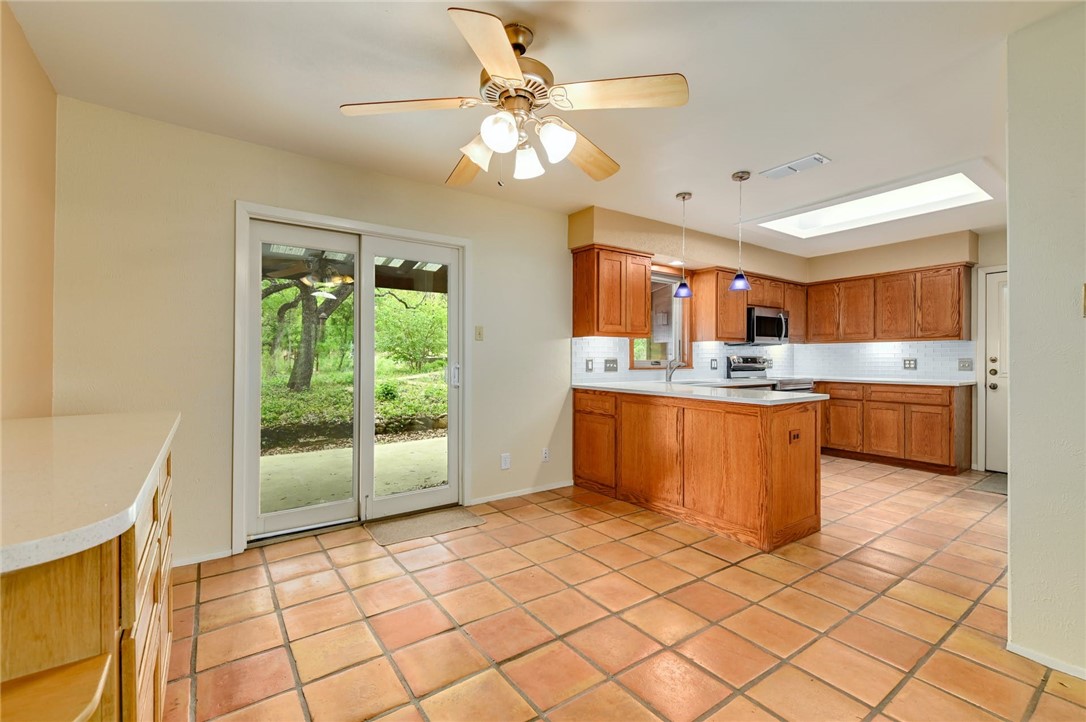901 Valley View Drive Austin, TX 78733 - Photo 7 of 25 a kitchen with stainless steel appliances kitchen island granite countertop a sink cabinets and window