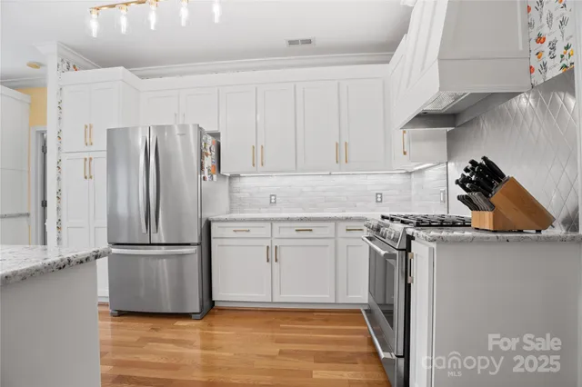 a kitchen with stainless steel appliances granite countertop a refrigerator and a stove