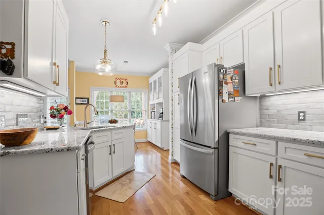 a kitchen with kitchen island granite countertop a sink appliances cabinets and counter space