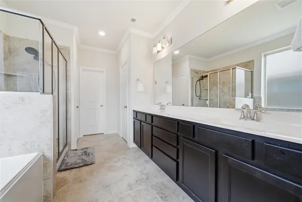 a spacious bathroom with a double vanity sink a and a large mirror