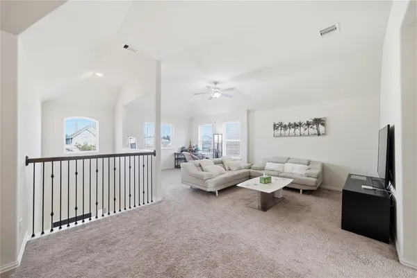 a living room with furniture a ceiling fan and a rug