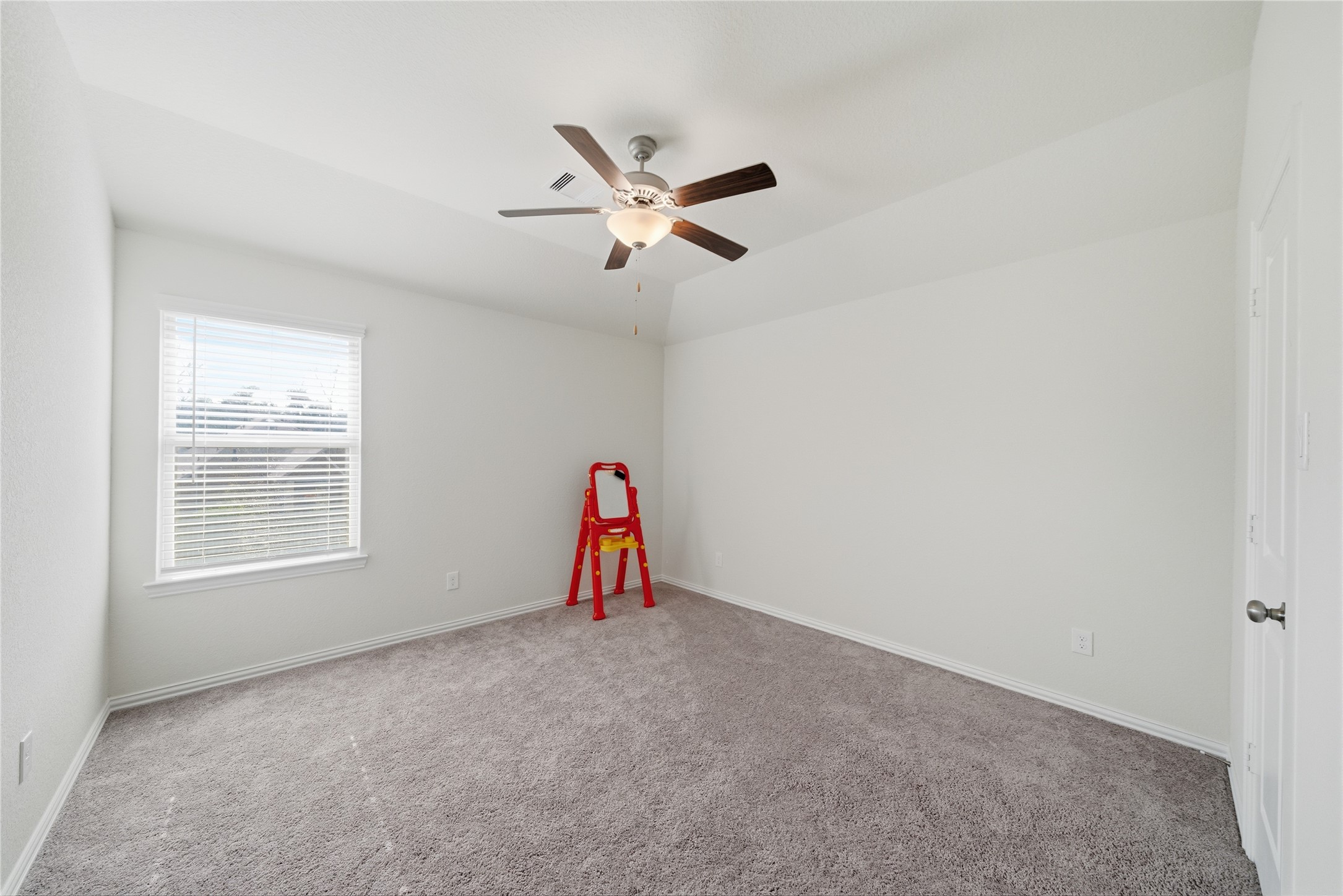 4335 Tawny Timber Drive Spring, TX 77386 - Photo 33 of 42 This room features freshly painted walls, a ceiling fan, and a large window for natural light. The neutral carpet adds warmth, making it a versatile space for a bedroom or office.