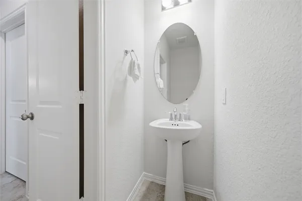 a bathroom with a sink a toilet a mirror and shower