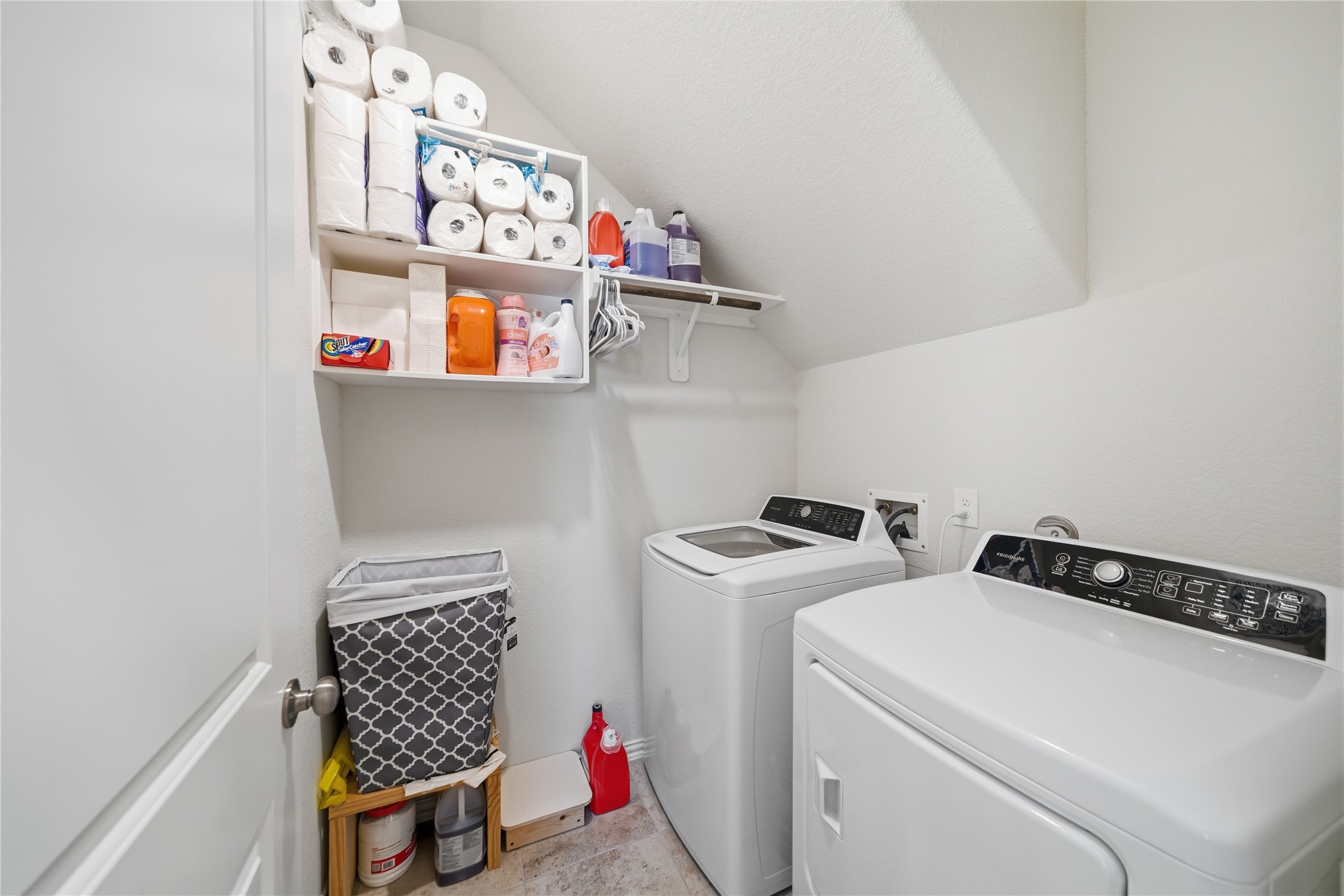 4335 Tawny Timber Drive Spring, TX 77386 - Photo 36 of 42 This laundry room features a modern washer and dryer set, efficient shelving for storage, and a clean, organized layout, perfect for household needs.