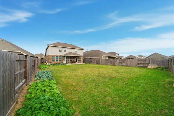 a view of a house with backyard and a garden