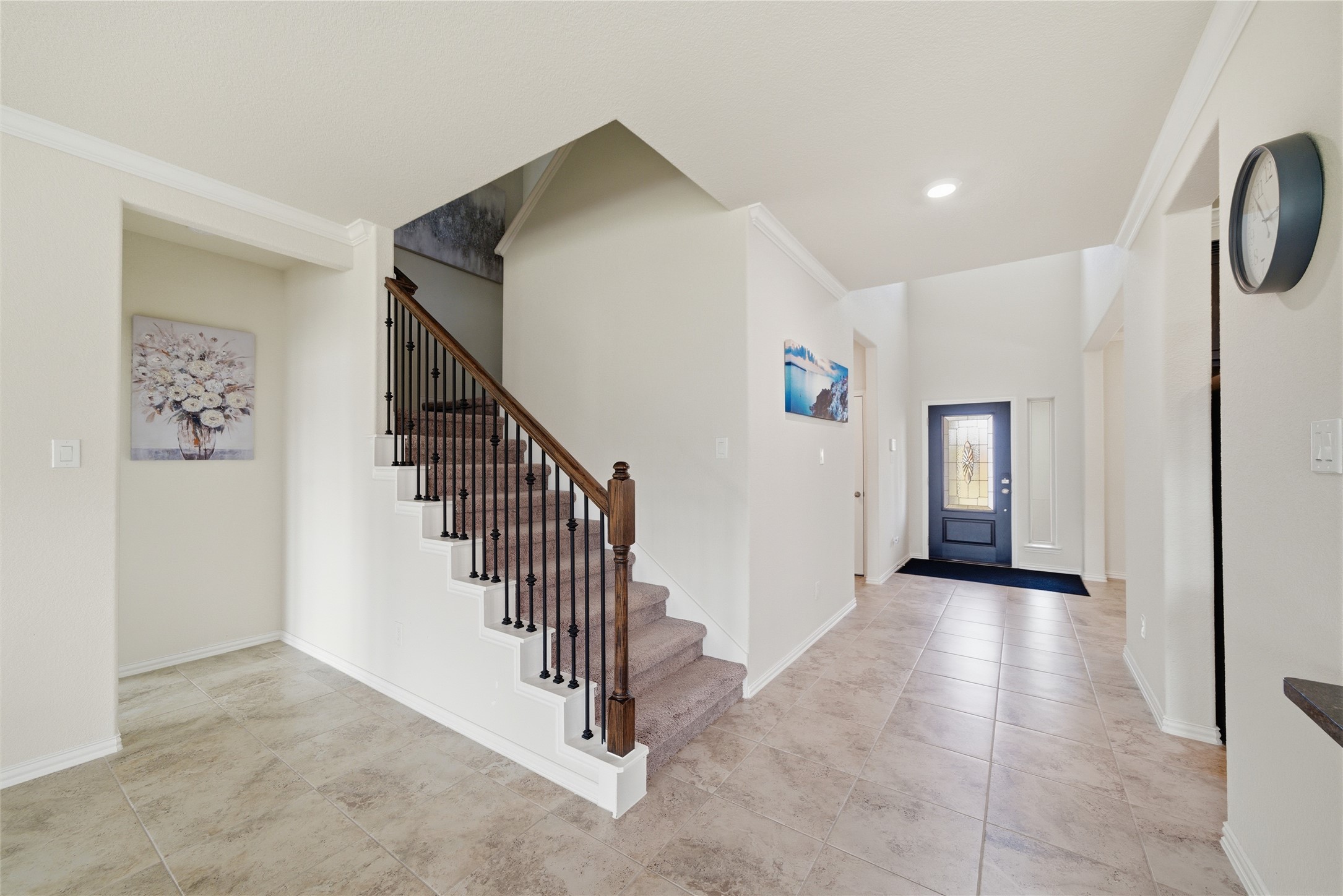 4335 Tawny Timber Drive Spring, TX 77386 - Photo 5 of 42 Bright and welcoming entryway with tiled flooring and a carpeted staircase featuring elegant iron balusters. The space is well-lit with a modern front door and high ceilings, giving a spacious feel. Perfect for creating a warm first impression.