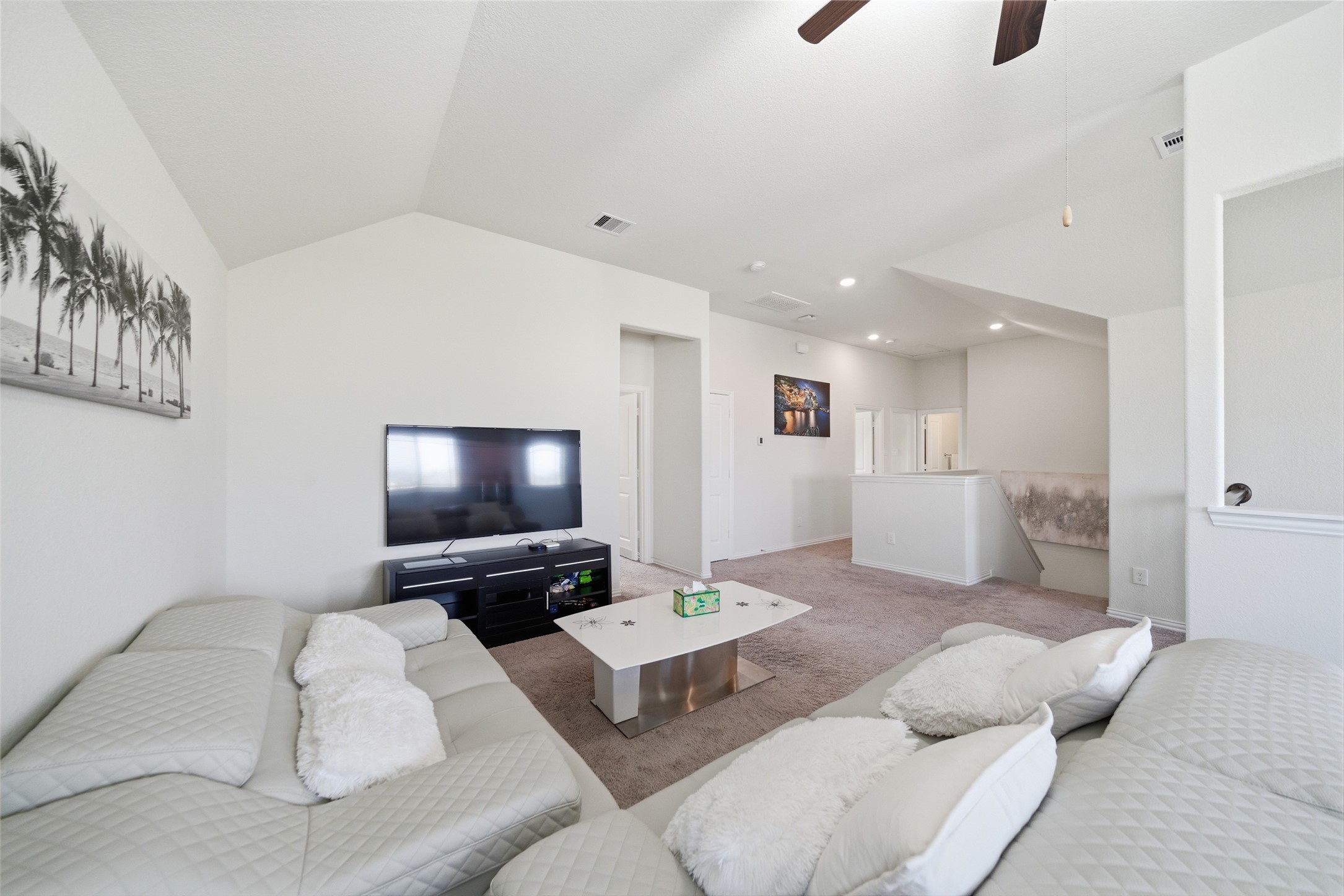 4335 Tawny Timber Drive Spring, TX 77386 - Photo 7 of 42 This bright and spacious living area features vaulted ceilings, modern furniture, and a large TV, perfect for relaxation and entertainment. The neutral color palette and open layout create a welcoming atmosphere.