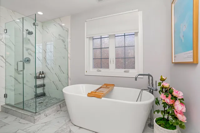 a white bath tub sitting next to a shower