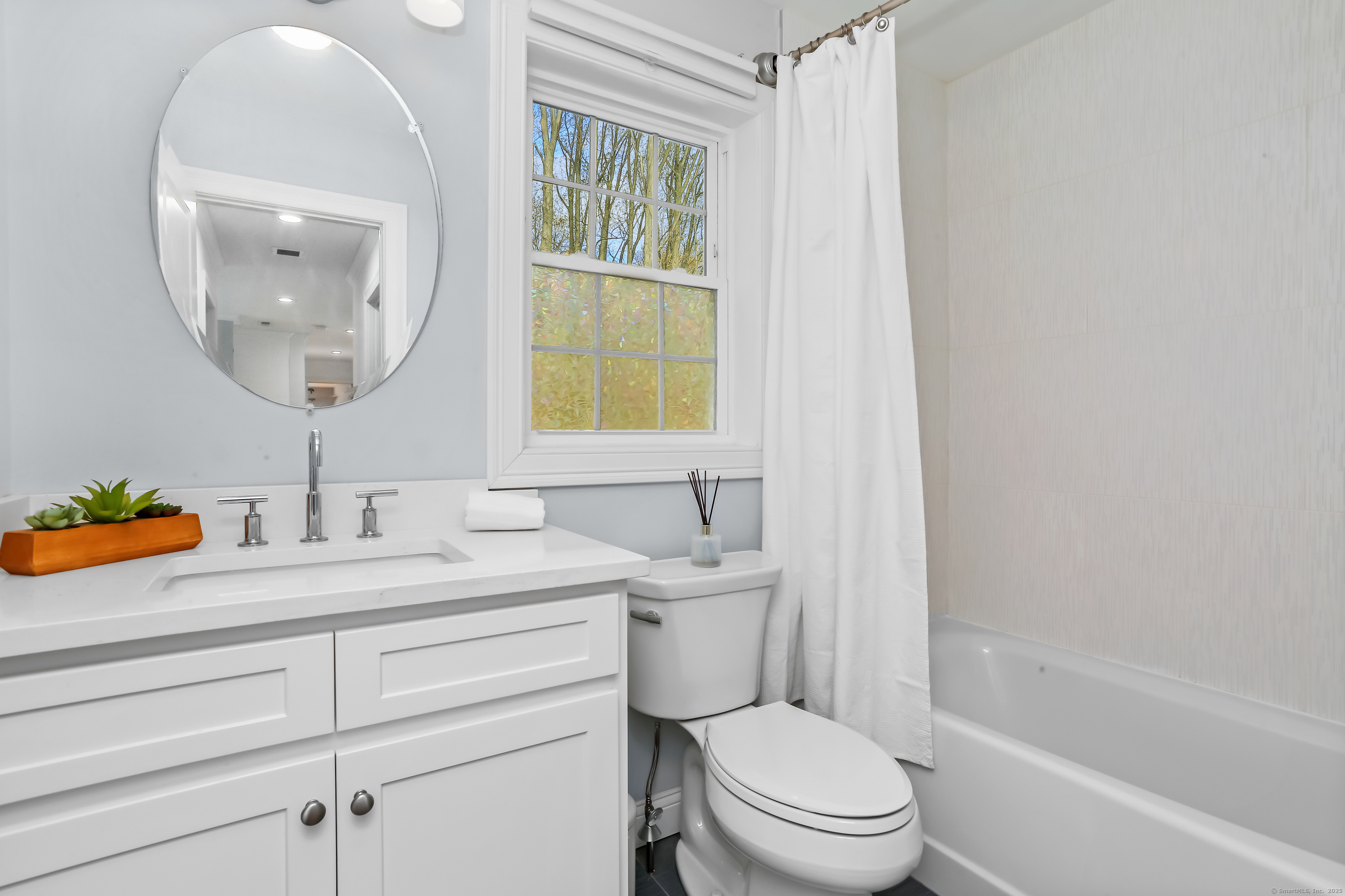 450 James Farm Road Stratford, CT 06614 - Photo 25 of 36 a bathroom with a toilet a sink a mirror and a window
