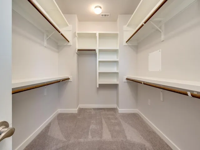 a view of walk in closet with empty racks