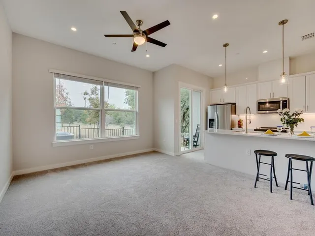 a living room with stainless steel appliances granite countertop furniture and a large window