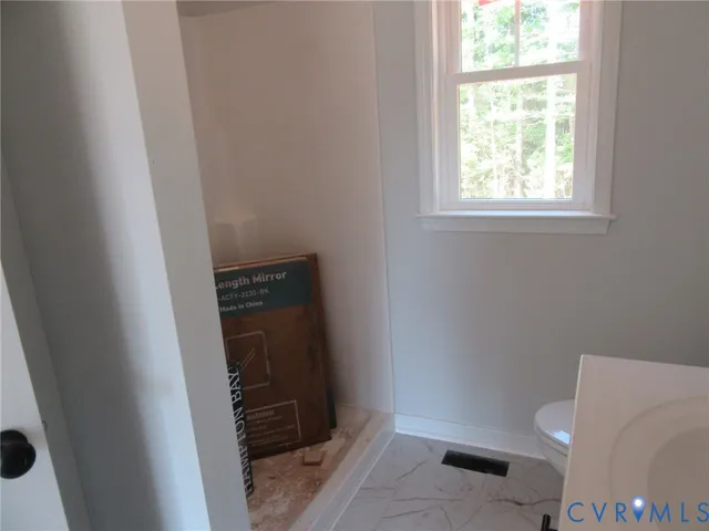 a bathroom with a toilet and a window
