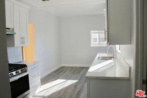 a kitchen with a sink and a stove top oven