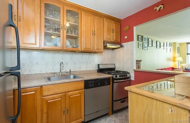 a kitchen with stainless steel appliances granite countertop a sink stove and cabinets
