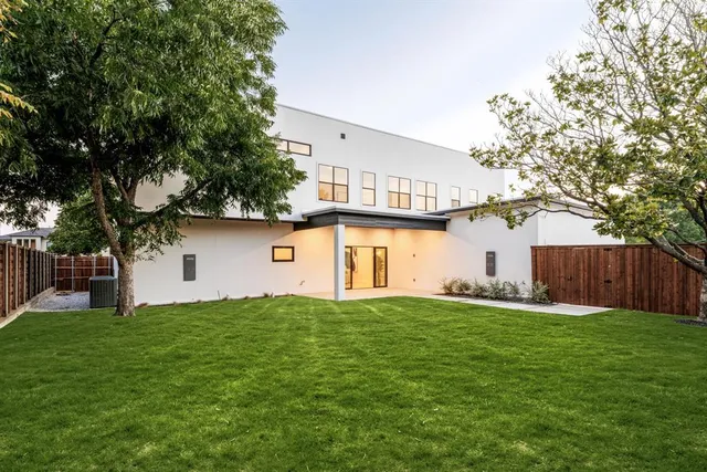 a front view of house with yard and trees in the background