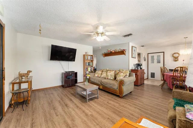 a living room with furniture a flat screen tv and wooden floor
