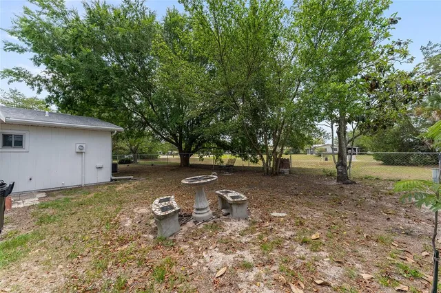 a backyard of a house with trees and outdoor seating