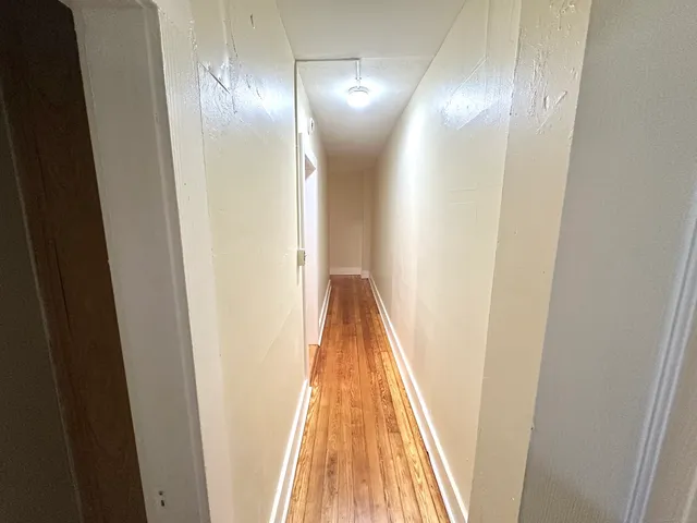 a view of a hallway with wooden floor