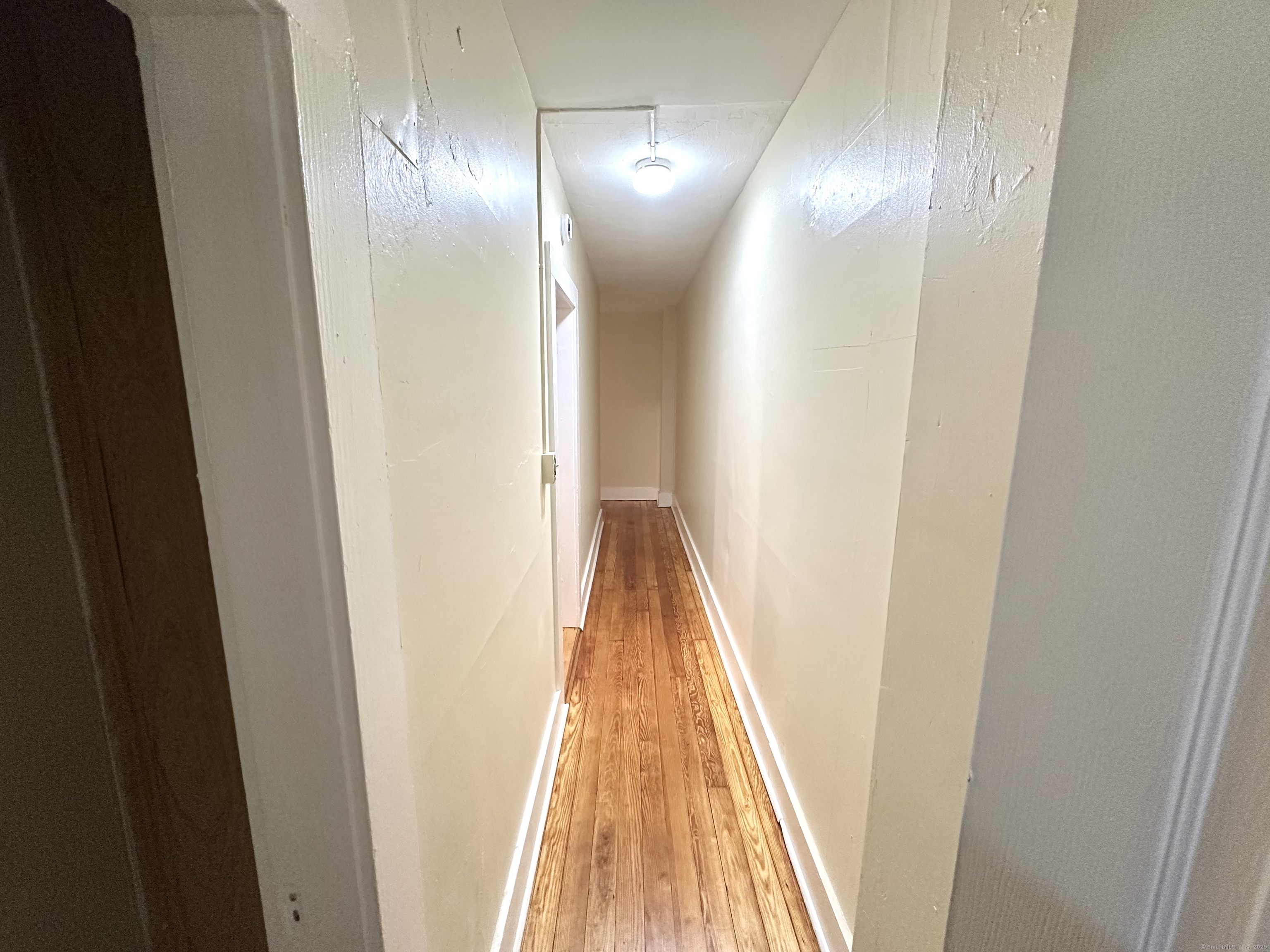 1019 West Main Street, Unit 3R Waterbury, CT 06708 - Photo 11 of 25 a view of a hallway with wooden floor